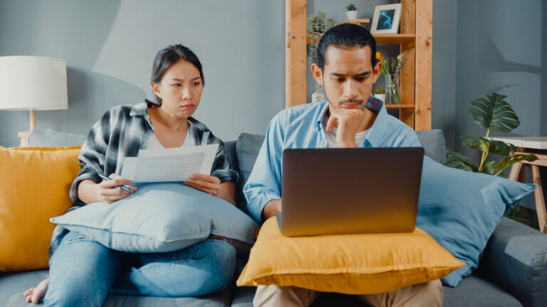 Asia young couple man and woman sit on couch serious focus on la